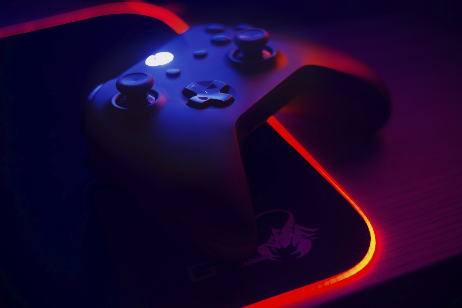Close-up of a game controller lit by neon